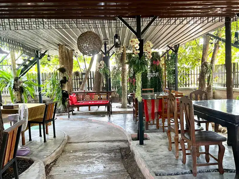 The open garden pavilion with wooden tables among the trees
