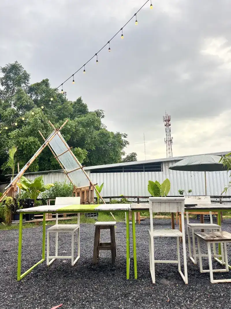 The yard by day: a bamboo A-frame, string lights and white chairs