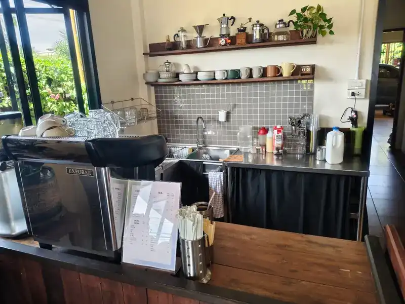 The coffee bar, with an espresso machine and cups on the shelves