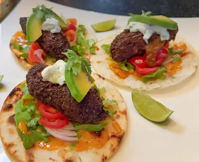 Falafel Tacos with avocado, tomato, herb sauce and lime
