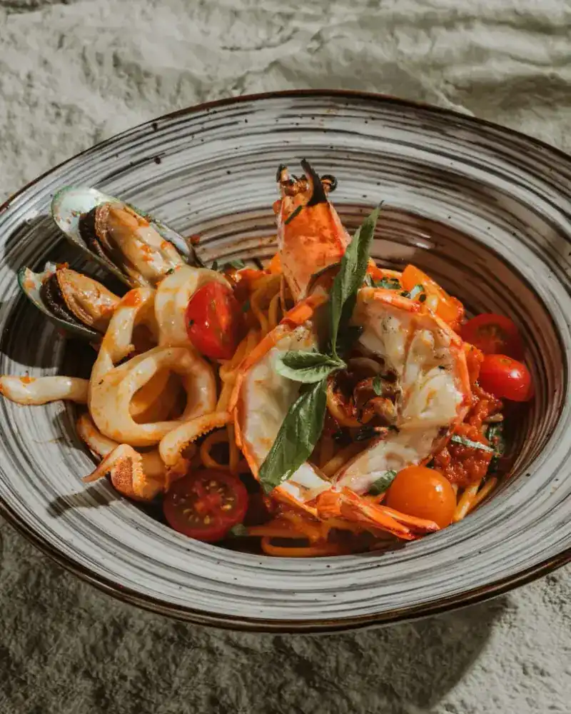 Seafood pasta with a tiger prawn, mussels, calamari, cherry tomatoes and basil