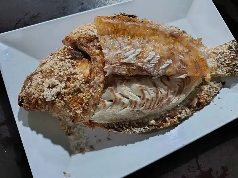 Salt-crusted grilled fish on a white plate / ปลาเผาเกลือบนจานสีขาว