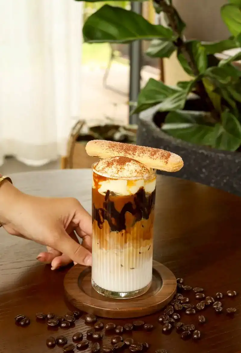 An iced tiramisu coffee topped with a ladyfinger biscuit