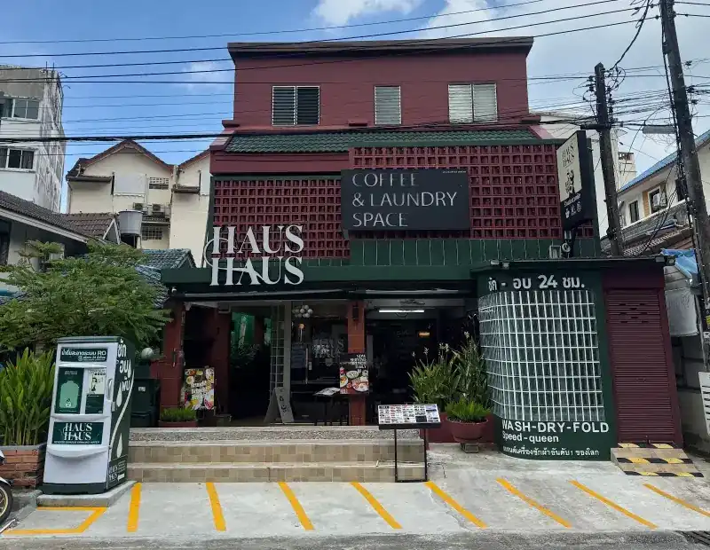 The Haus Haus building on Nanai Road: dark red front, green awning and the laundry's glass-block corner