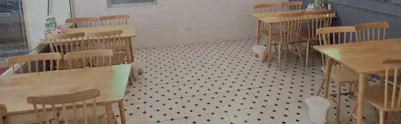 The dining room: wooden tables and chairs on a black-and-white tiled floor