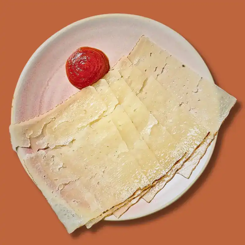 Slices of Manchego cheese with tomato chutney