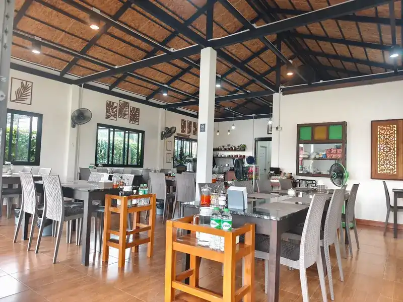 Inside: tables and chairs under a woven ceiling
