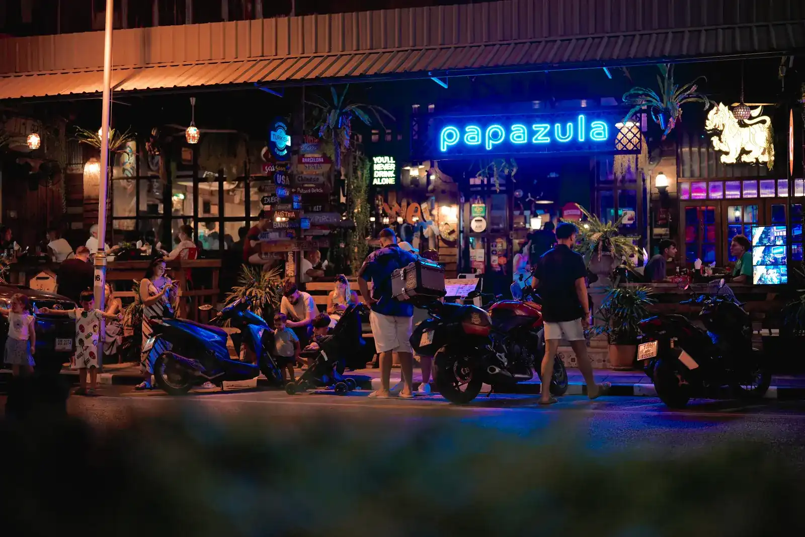 The blue neon papazula sign above the terrace on Phuket Road at night