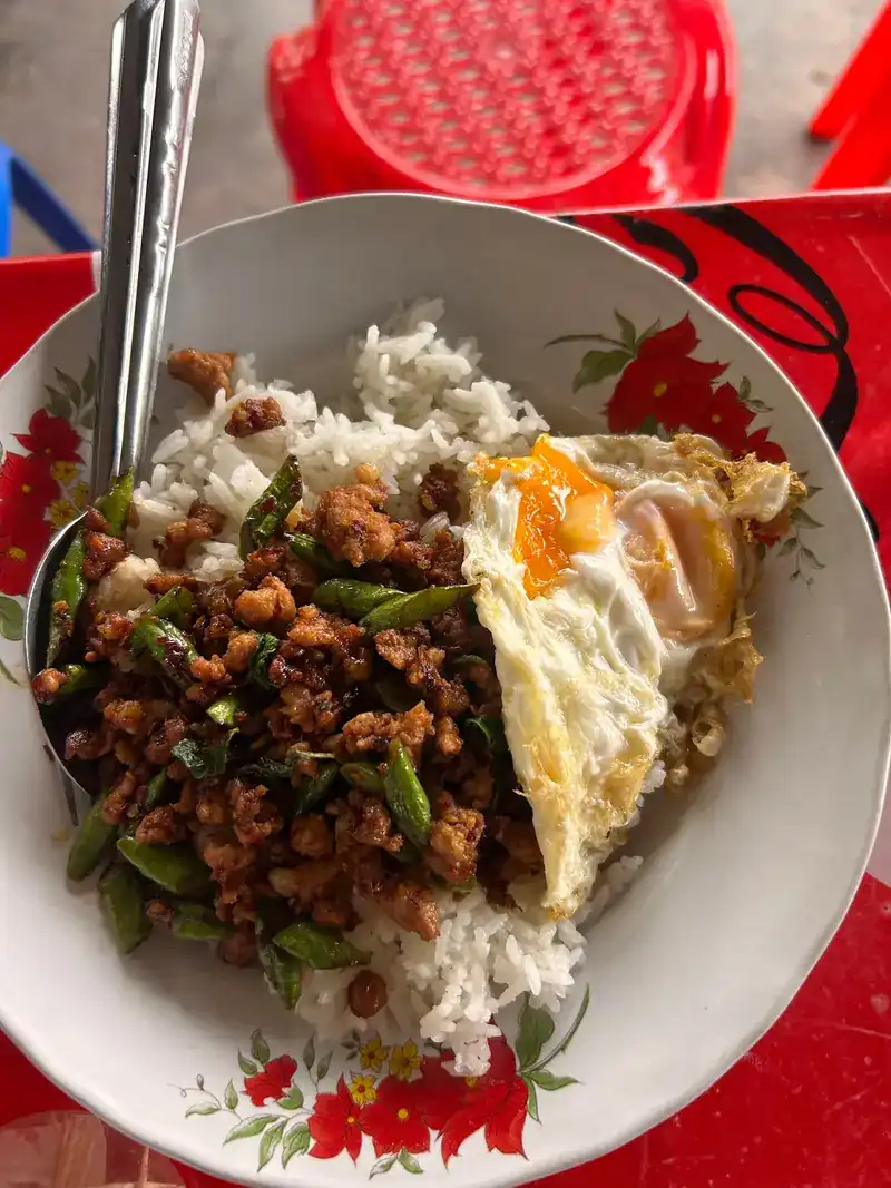 Minced pork stir-fried with long beans over rice, with a fried egg