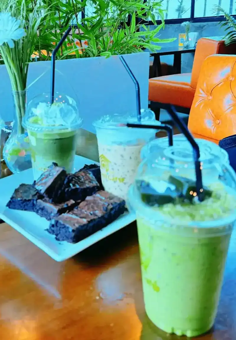 Brownies and cold drinks on a table beside the bamboo. บราวนี่และเครื่องดื่มเย็นบนโต๊ะข้างต้นไผ่