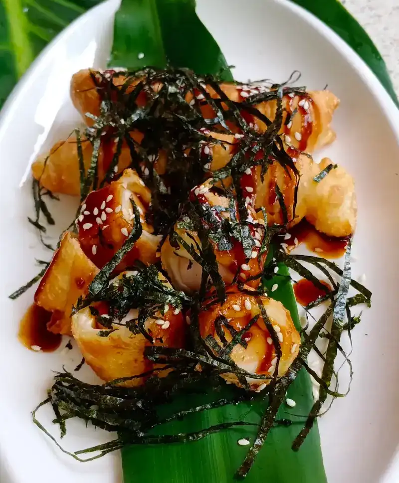 Fried pieces with a dark sweet sauce, sesame and shredded seaweed