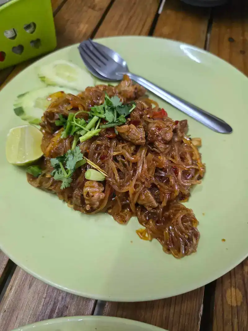 Stir-fried glass noodles with coriander, cucumber and lime on a green plate