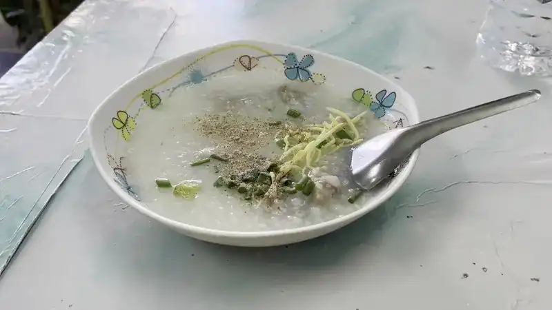 Rice porridge topped with shredded ginger, spring onion and pepper