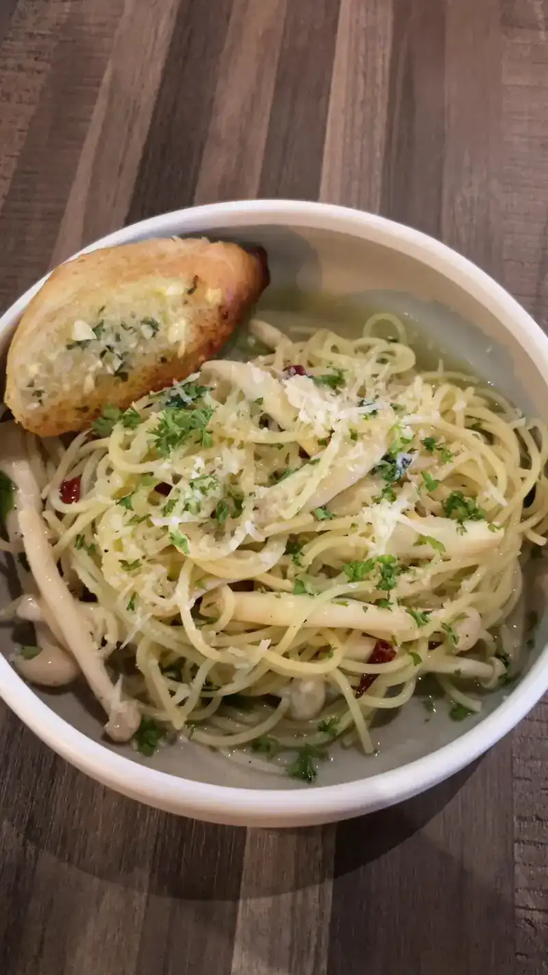 Spaghetti with mushrooms, chilli flakes and parmesan, with a slice of garlic bread