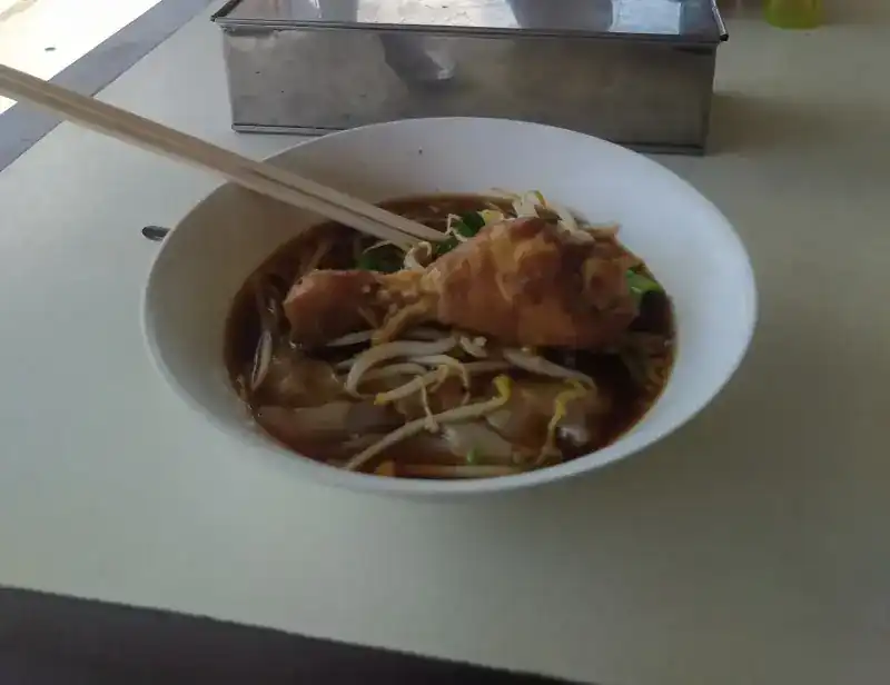 Noodle soup with a chicken drumstick and bean sprouts