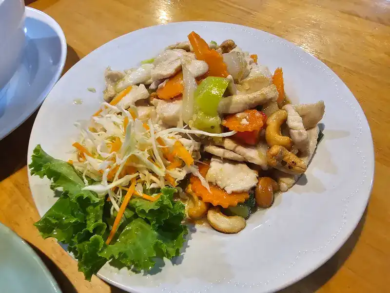 Stir-fried chicken with cashew nuts, carrot and pepper, with lettuce and shredded cabbage
