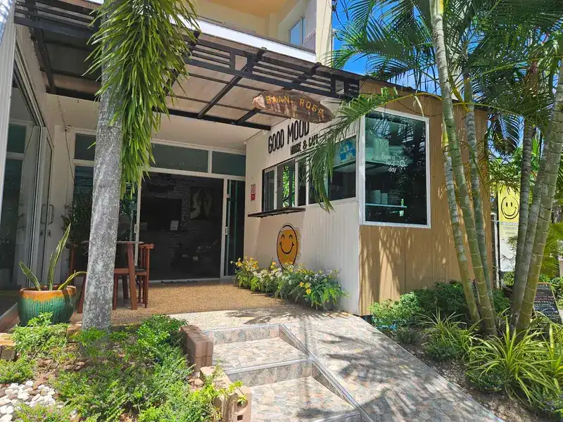 The café front with its Good Mood sign, a smiley and palms