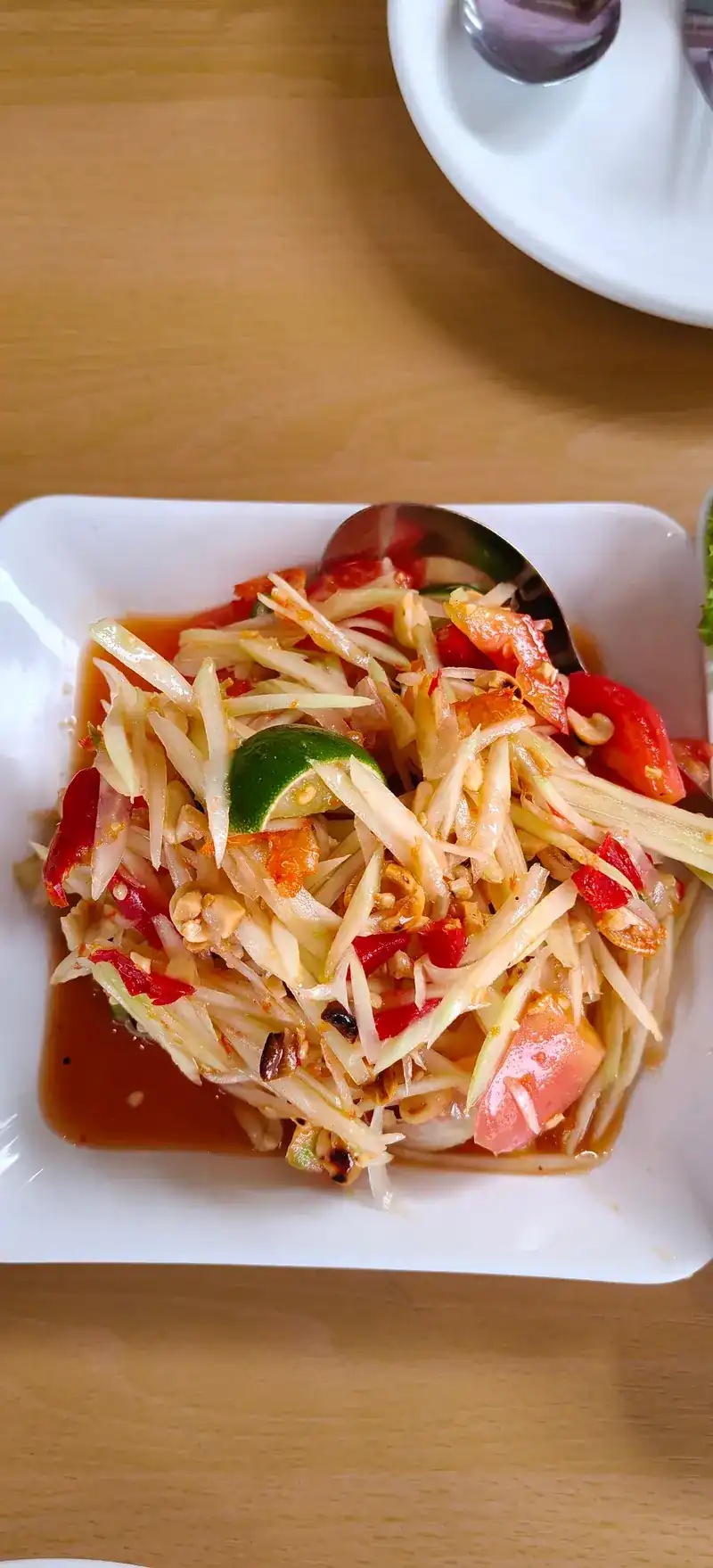Papaya salad with chilli and lime on a white plate