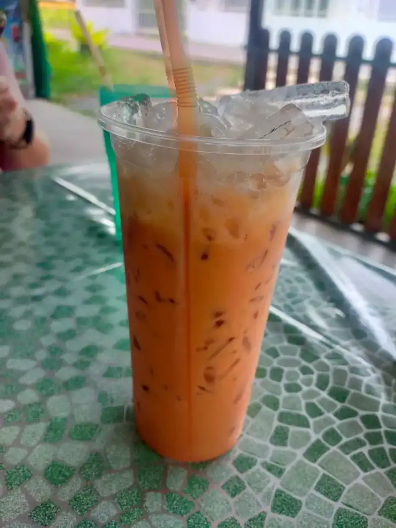 Thai iced tea on a green mosaic tablecloth / ชาเย็นบนผ้าปูโต๊ะลายโมเสกสีเขียว