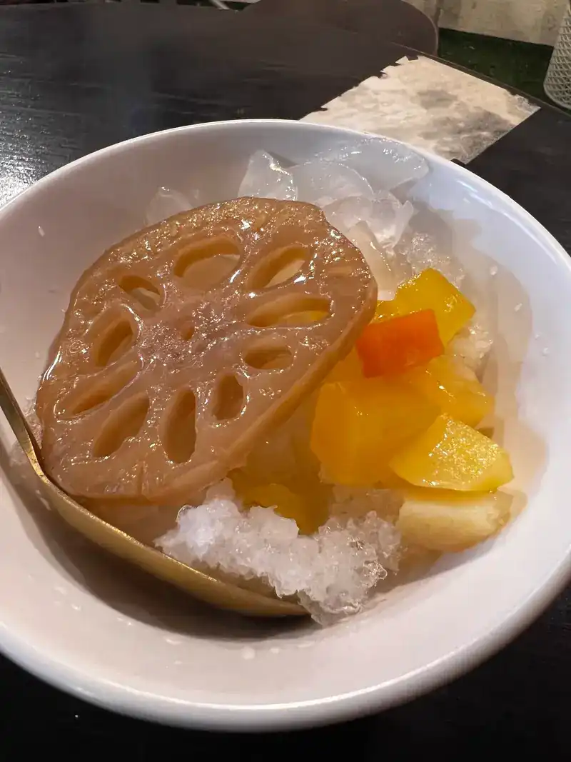 Candied lotus root with yellow and orange pieces on shaved ice