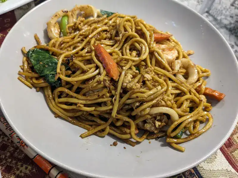 Stir-fried noodles with squid, prawns, carrot and greens