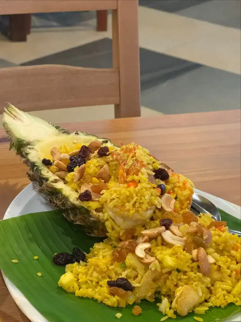Pineapple fried rice with cashews and raisins, served in half a pineapple