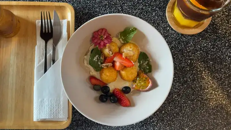 Syrniki with cream, strawberries, blueberries and passion fruit, seen from above
