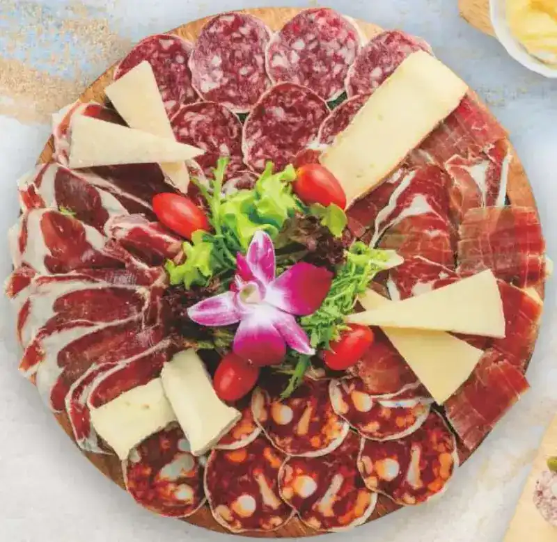 A round board of Iberian ham, sausage and cheese