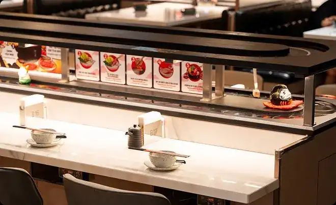 Counter seats under the capsule track at Shabu In