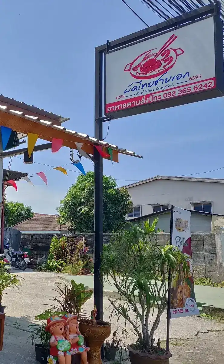 The red and white Pad Thai ChayEak sign at the shop entrance, with plants and coloured bunting