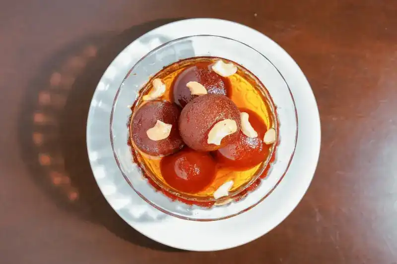 Gulab jamun in syrup topped with cashews