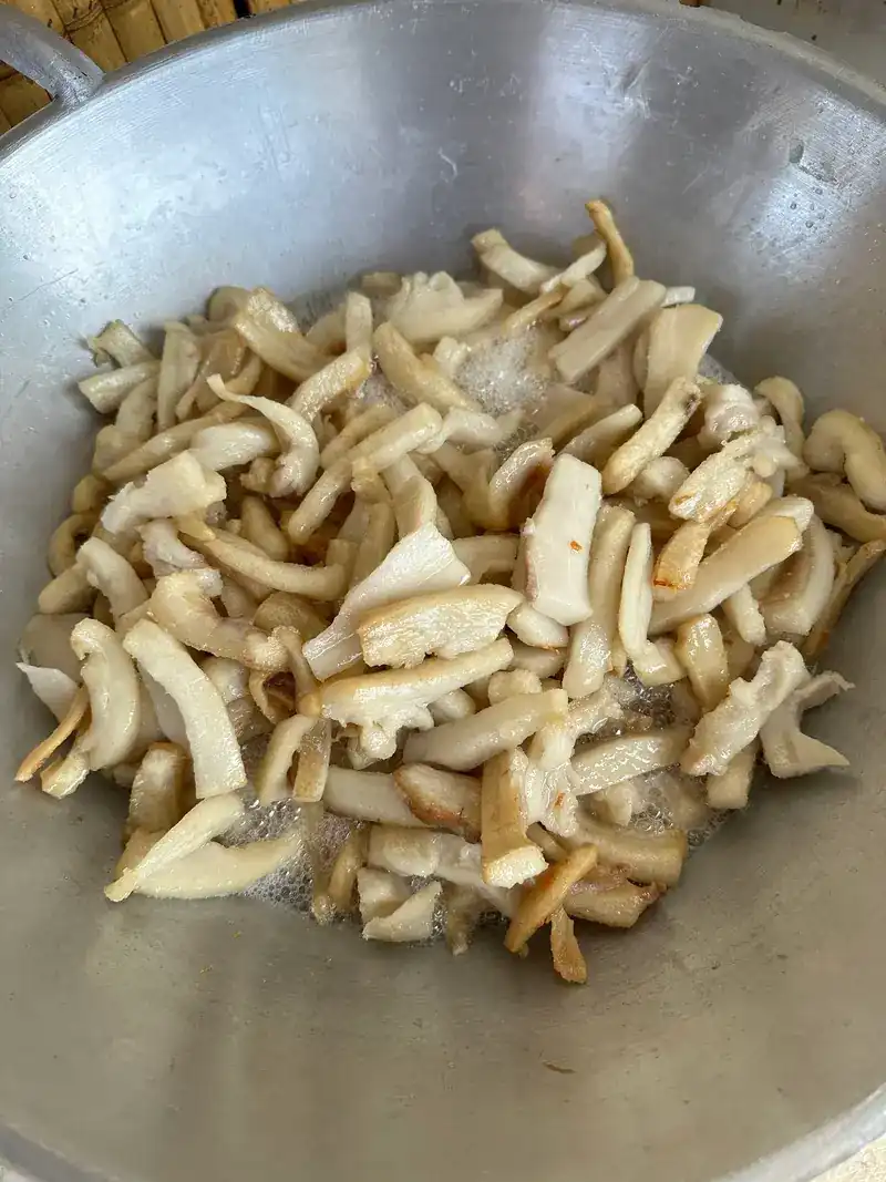 Pieces of pork frying in a large pan