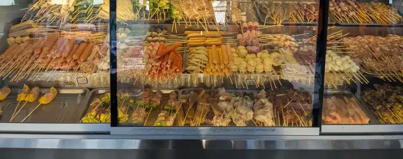 The glass chiller cabinet, every shelf full of skewers