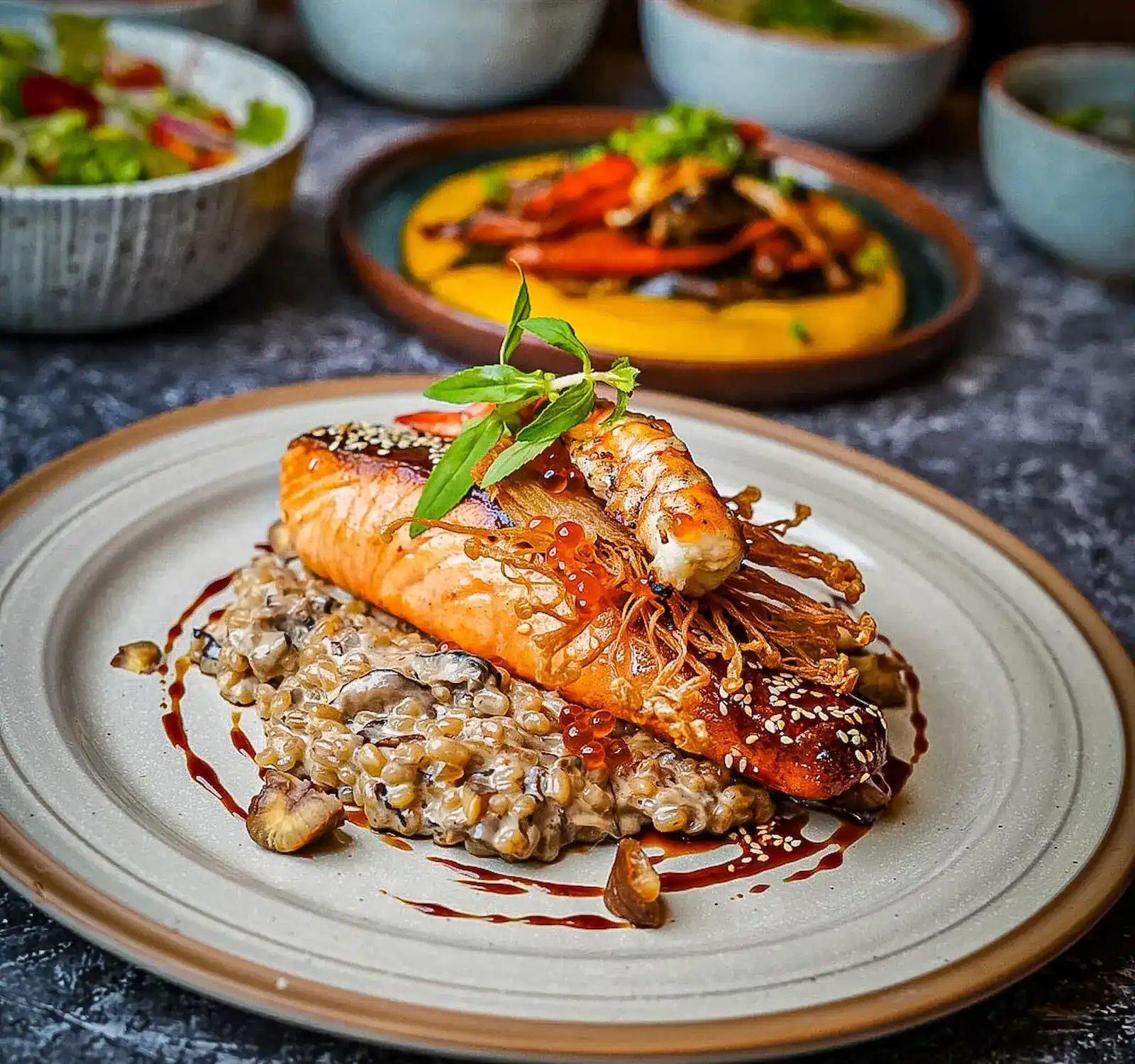 Salmon teriyaki on mushroom risotto, with more plates behind