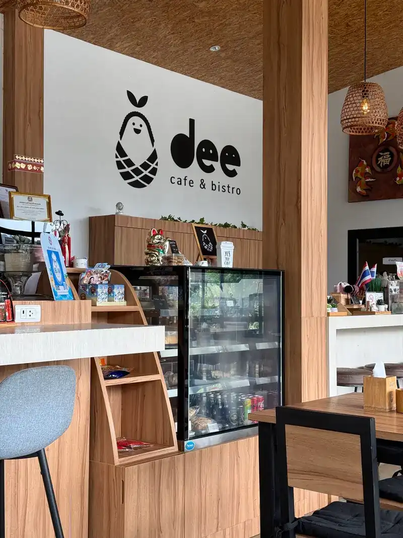 Inside dee: the logo wall, a glass display fridge and timber posts