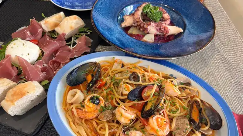 Raw ham with mozzarella, octopus, and seafood spaghetti on one table