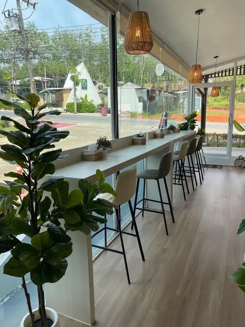 The long counter along the window, with high stools, rattan lamps and potted plants