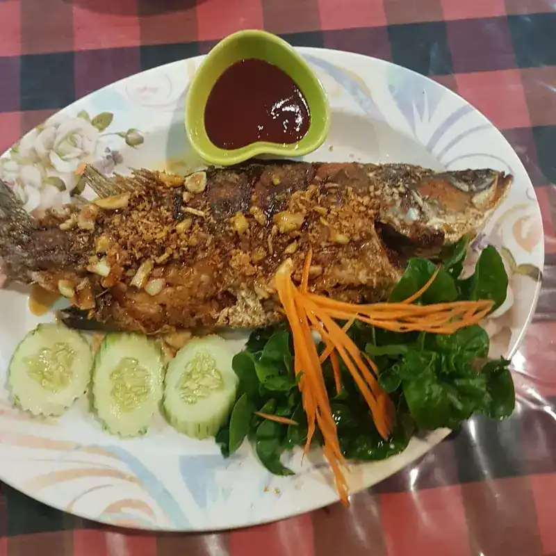 Whole fried fish topped with crisp garlic, with cucumber and a chilli dip / ปลาทอดโรยกระเทียมเจียว กับแตงกวาและน้ำจิ้ม