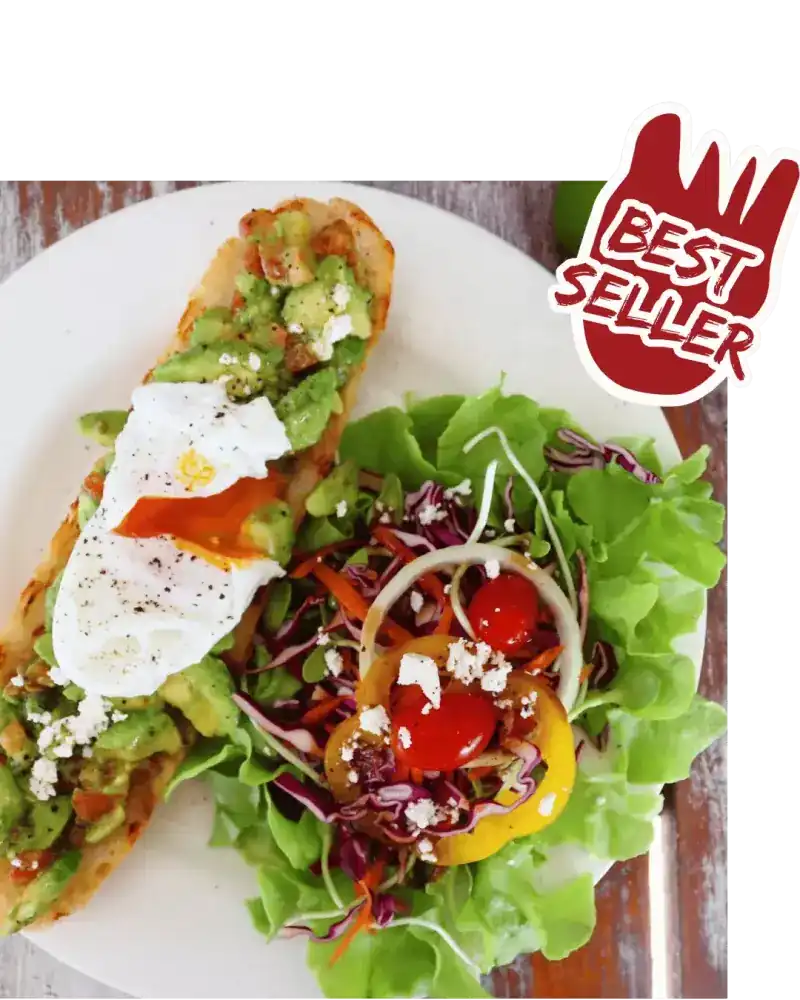 Smashed avocado on toast with a poached egg and a salad