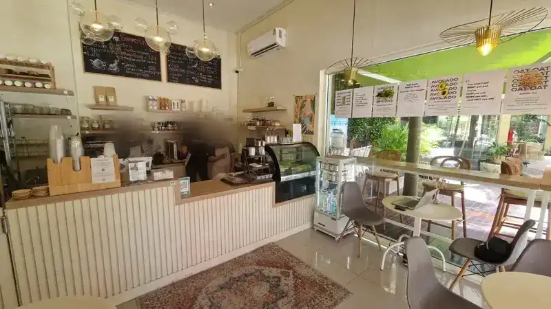 Inside the café: the counter, pendant lights and seats by the big window