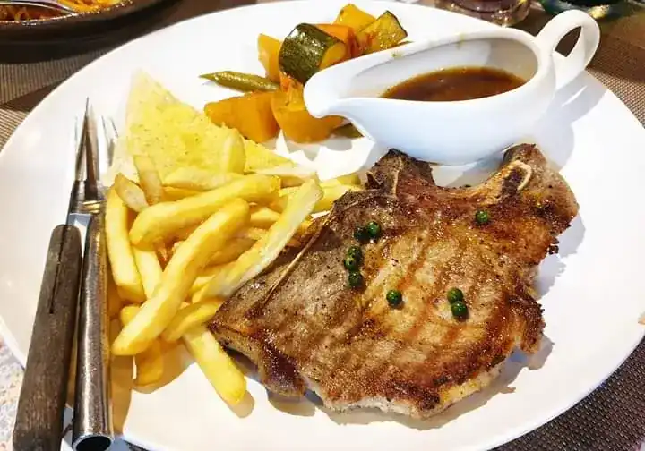 Grilled pork chop with fries, garlic toast and pepper sauce