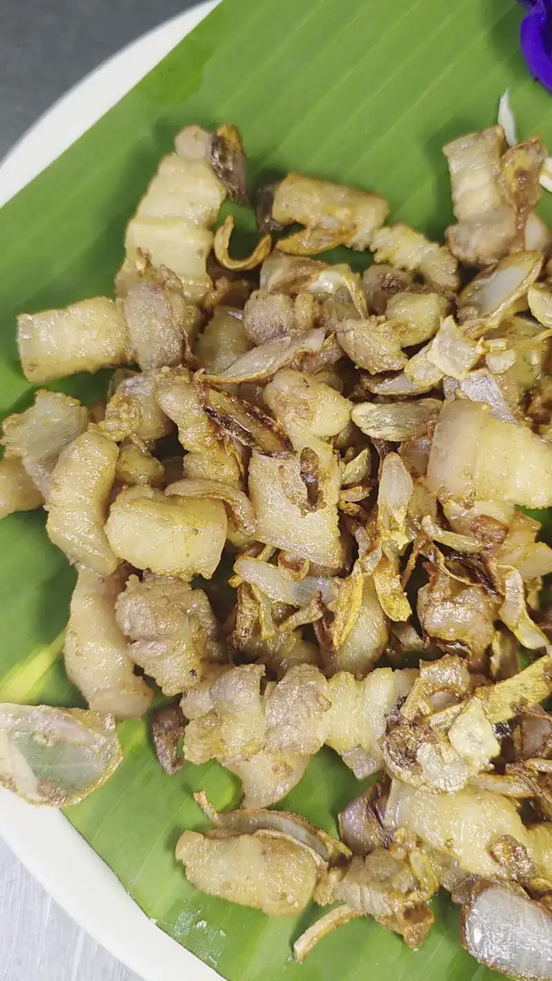 Pieces of pork fried crisp, on a banana leaf