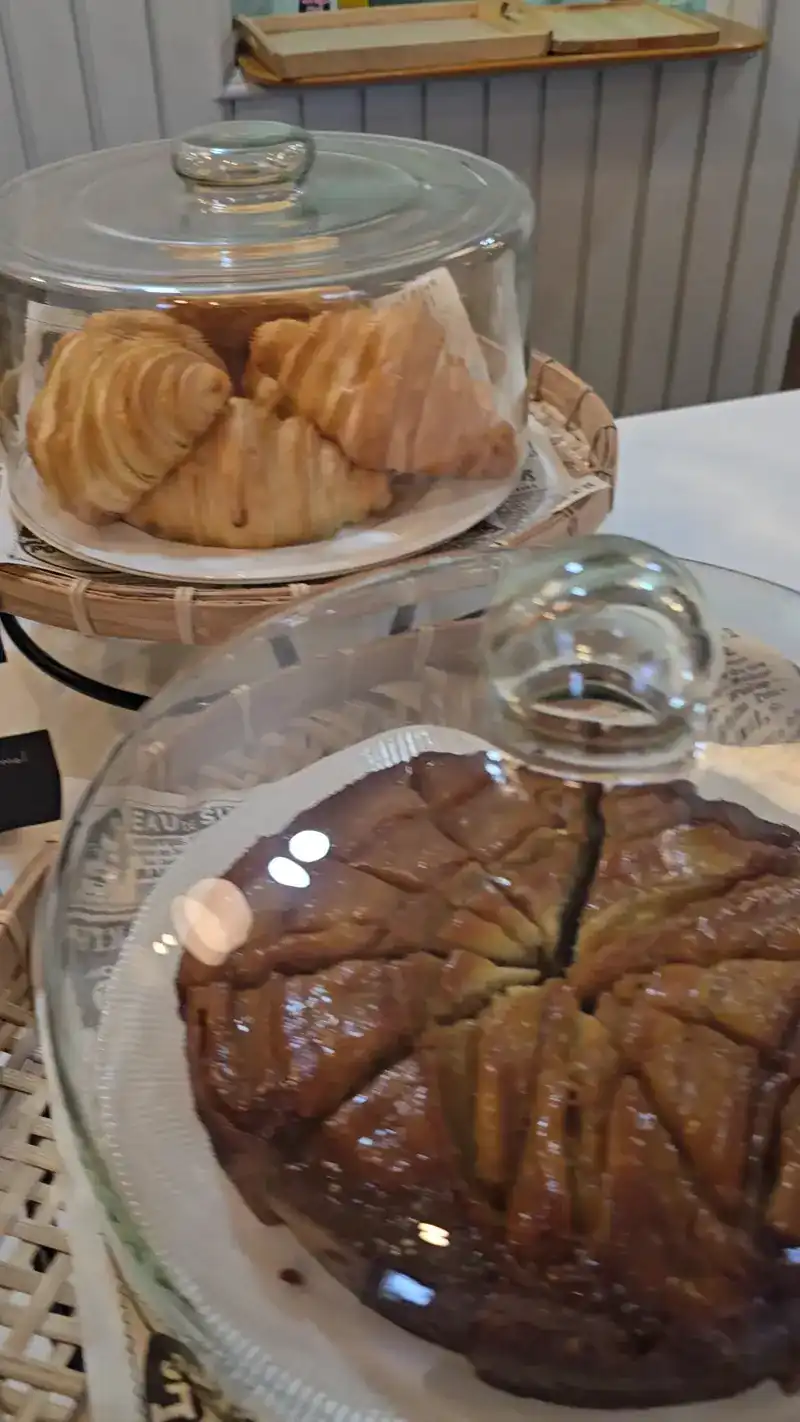 Croissants and a cake under glass domes on the counter