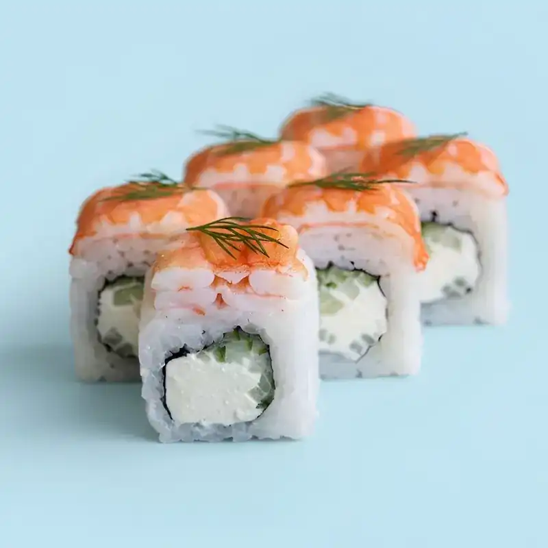 Rolls topped with prawn and dill, cream cheese and cucumber inside, on a light blue background