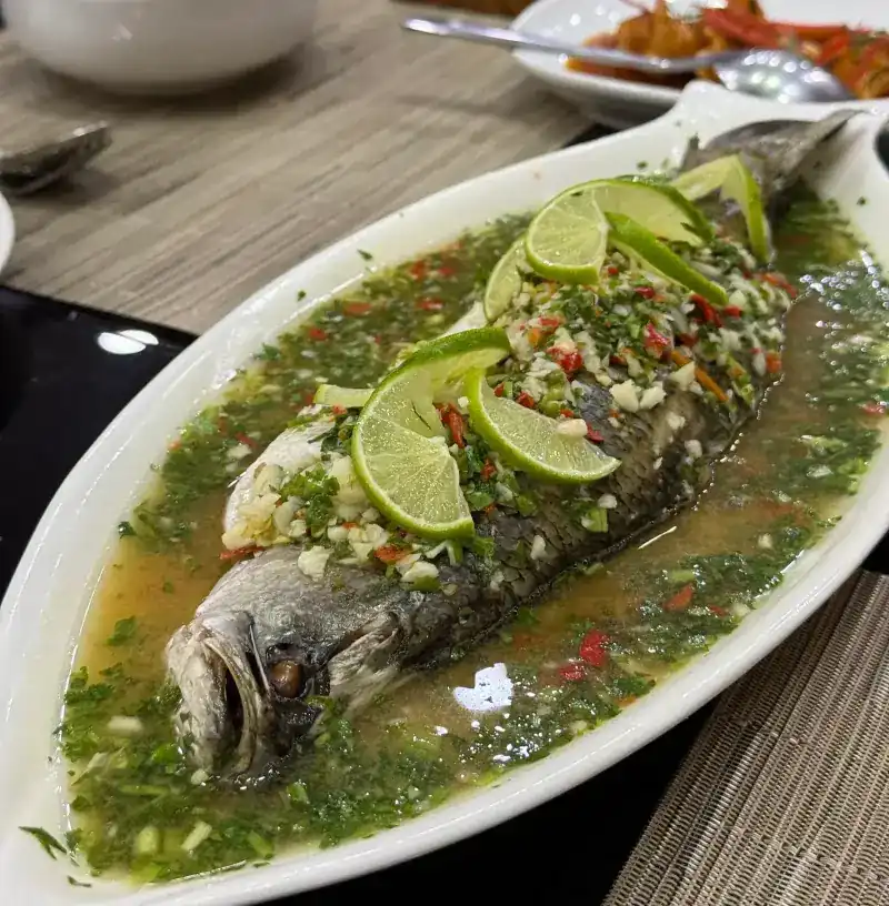 A whole steamed fish in a lime, garlic and chilli broth / ปลานึ่งมะนาวทั้งตัว ราดน้ำมะนาว กระเทียม และพริก