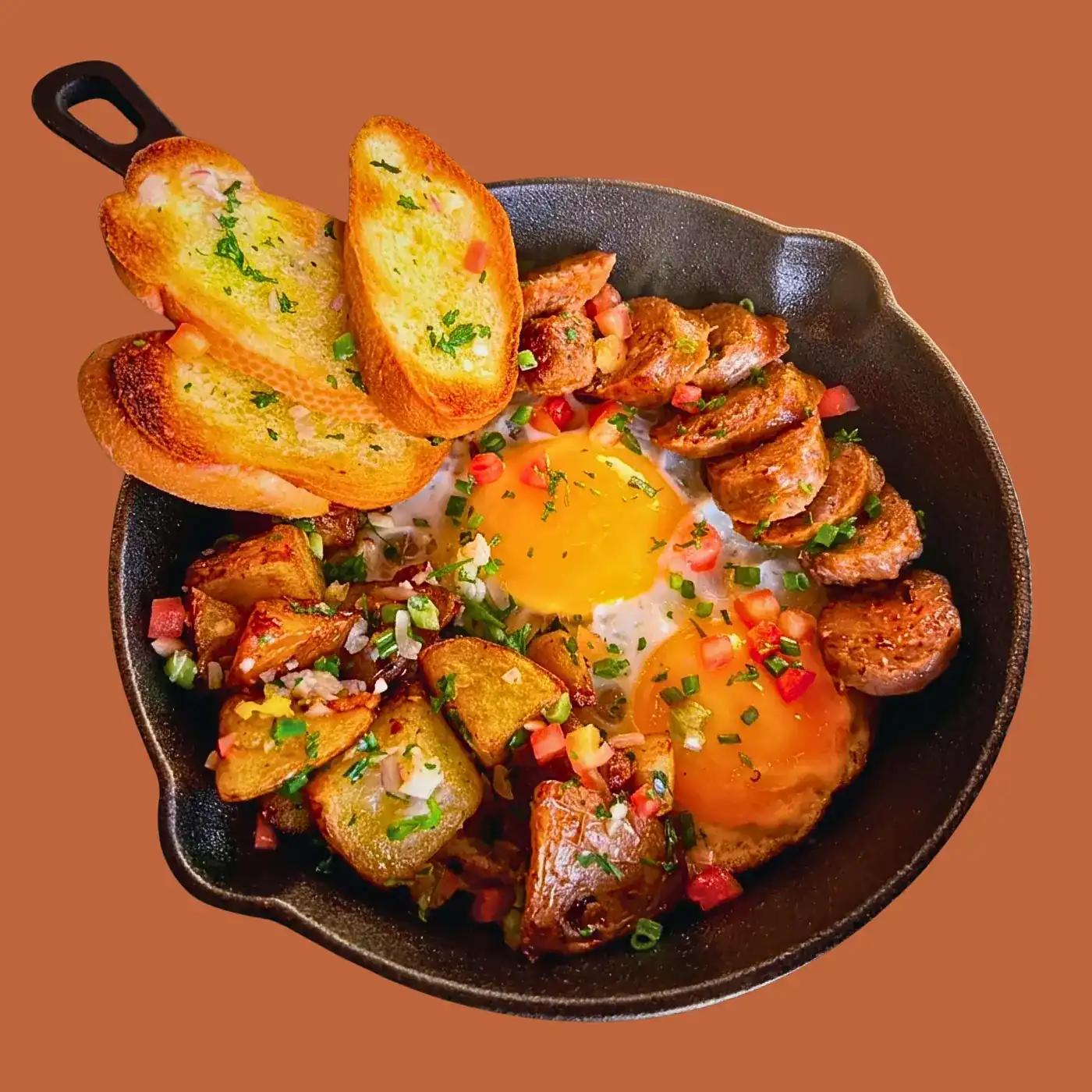 Txistorra and eggs in a cast-iron skillet with potatoes and toasted bread