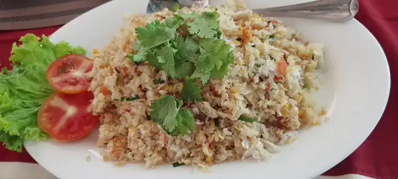 Fried rice with coriander, tomato and lettuce on a white plate