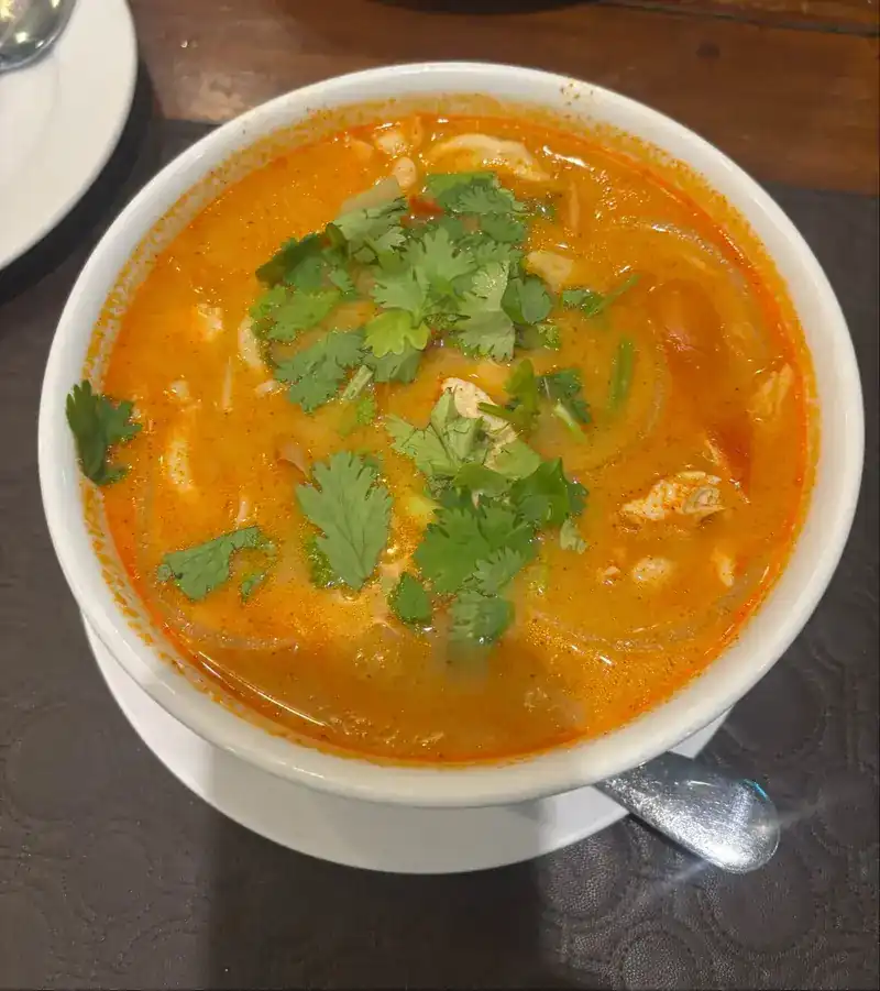 A bowl of orange soup topped with coriander