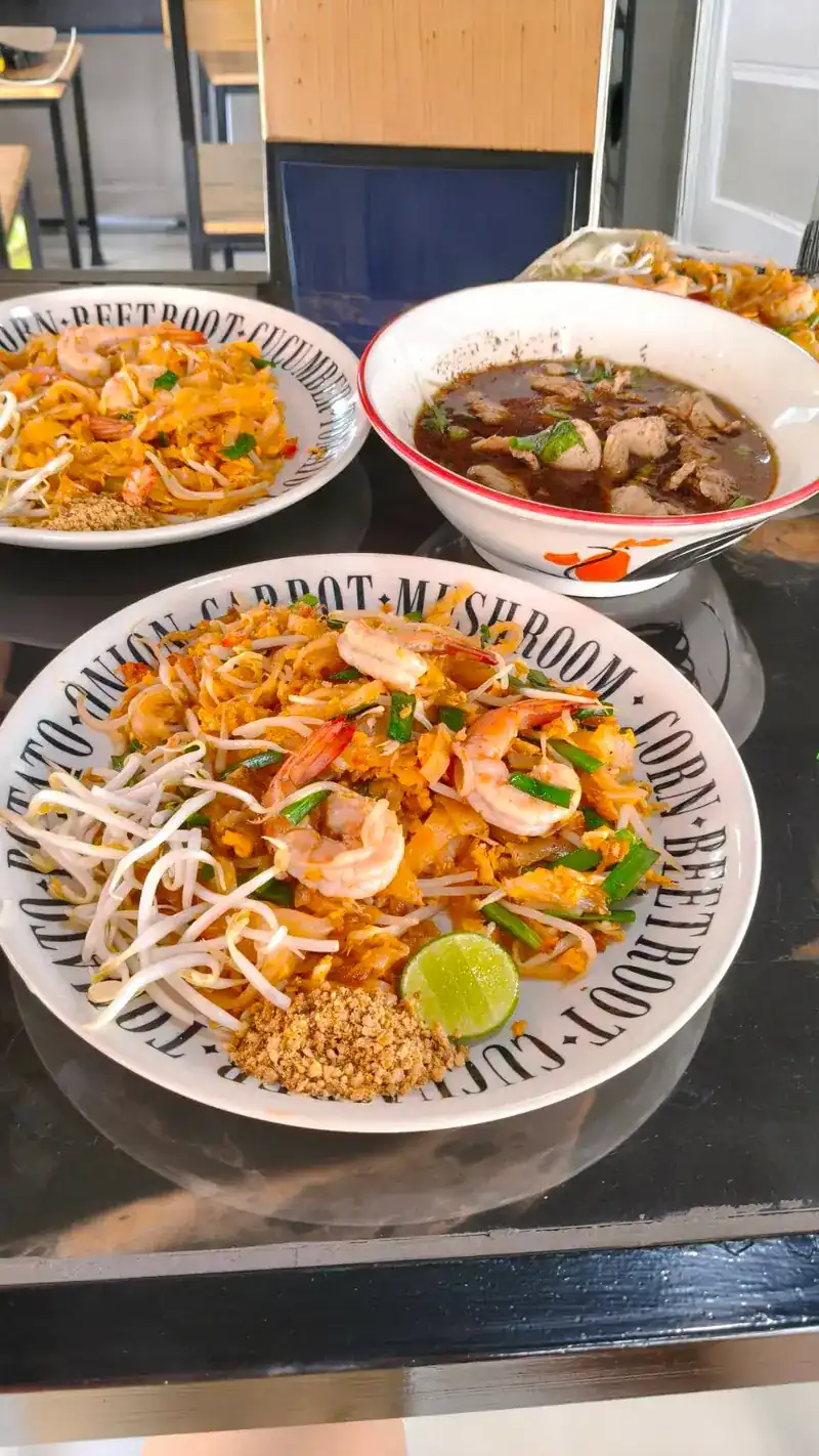 Pad thai with prawns, lime and bean sprouts, with boat noodles behind