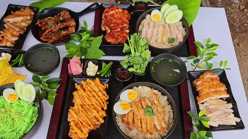 Rice plates with sliced chicken and crispy chicken with sauce and boiled egg, beside bowls of green noodles and clear soup